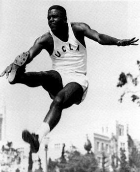 Jackie Robinson wearing a UCLA jersey competing in the long jump event.