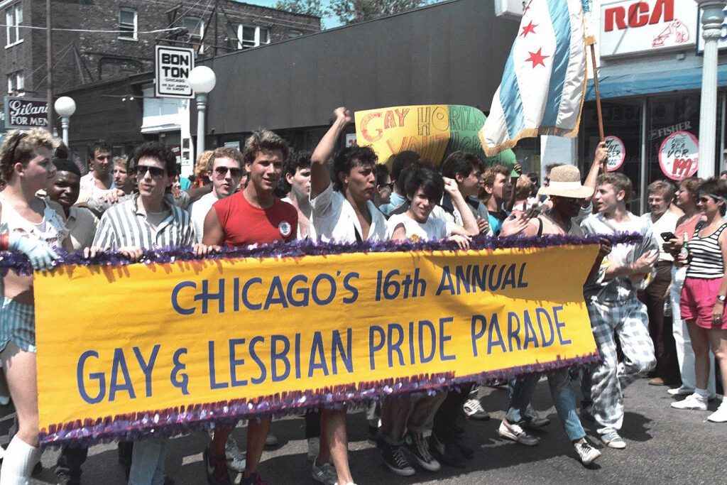 Group of people at Chicago Pride Parade holding a big yellow banner.