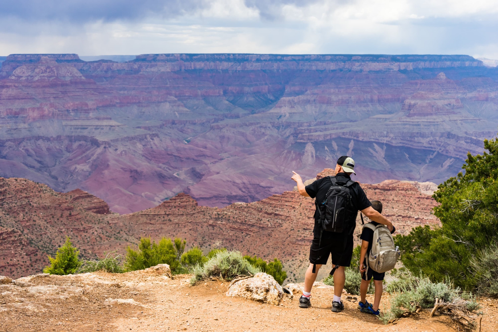 A man and child looking at the Grand Canyon