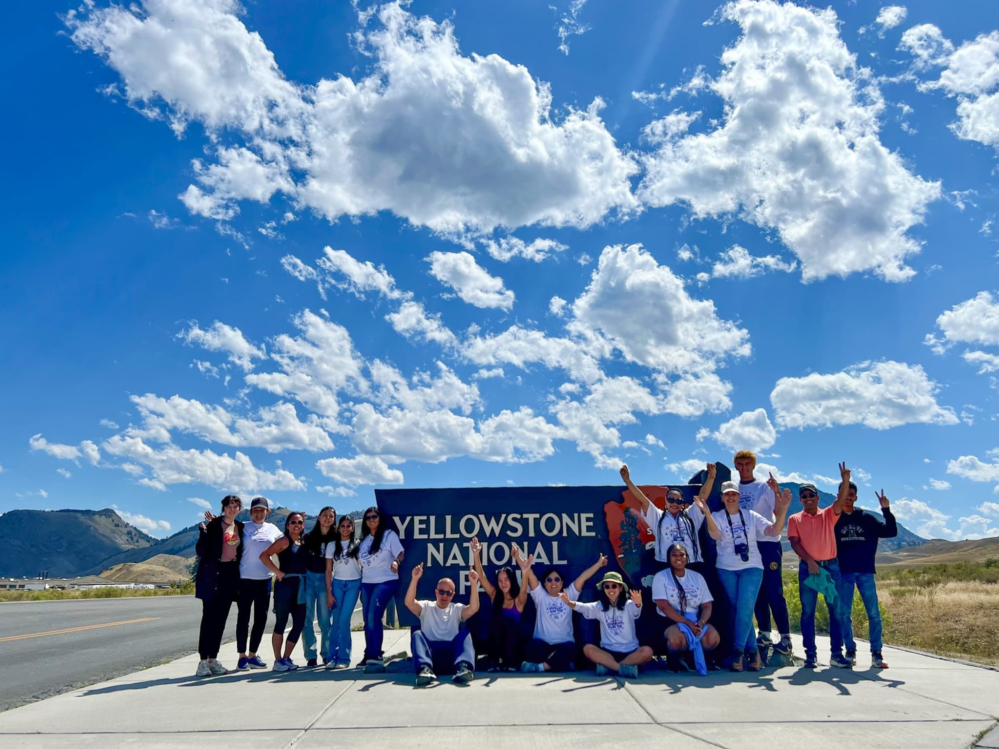 Students in front of a sign that reads "Yellowstone National Plaza