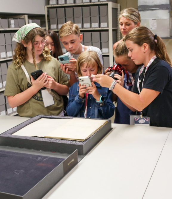 Winning students taking a photo of a historical artifact