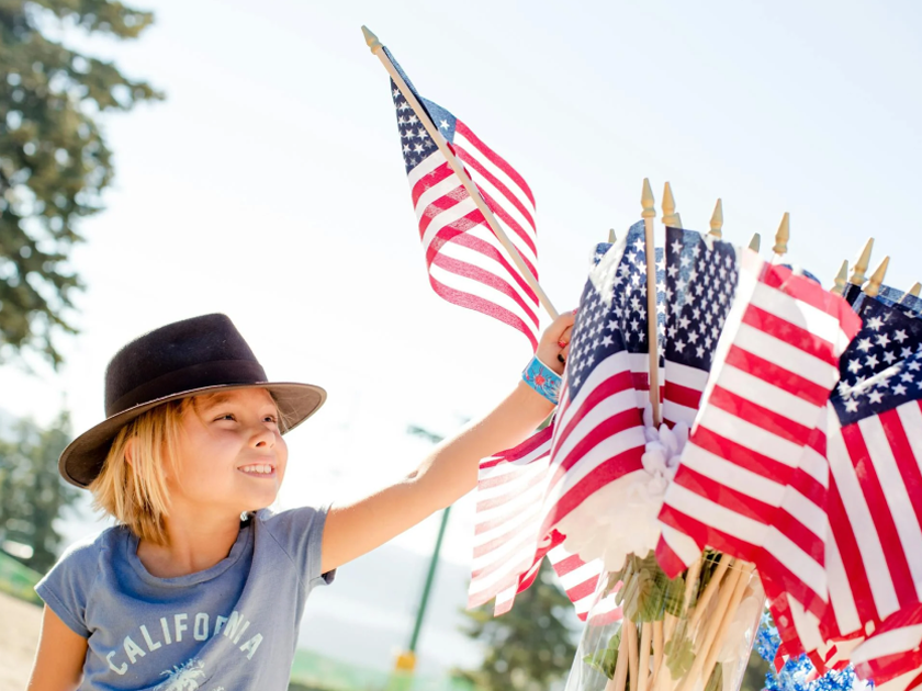 A child taking a small American Flag from a collection of American Flags