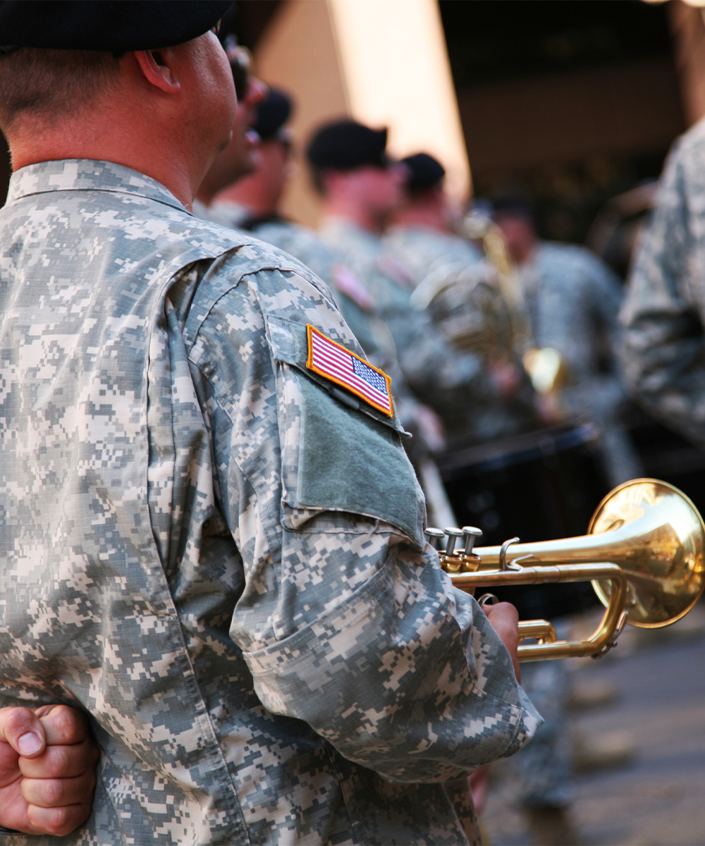 US soldier carrying a trumpet standing in formation