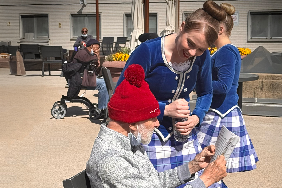 Young volunteer in costume shares a joyful moment with a senior during a community outreach visit.