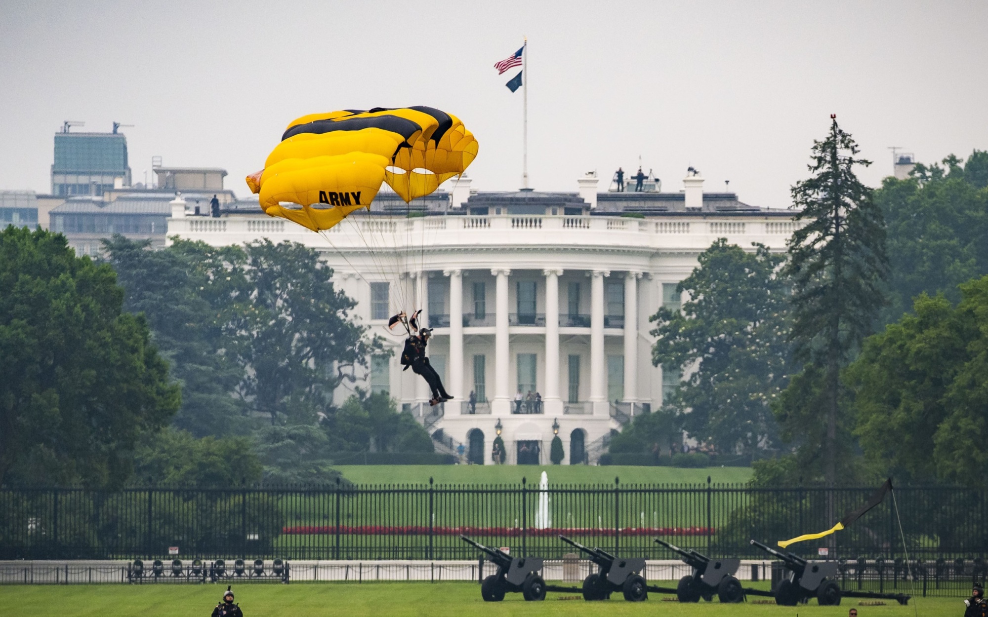 U.S. Army Golden Knights parachute jumper landing on the Ellipse, with the White House in the background