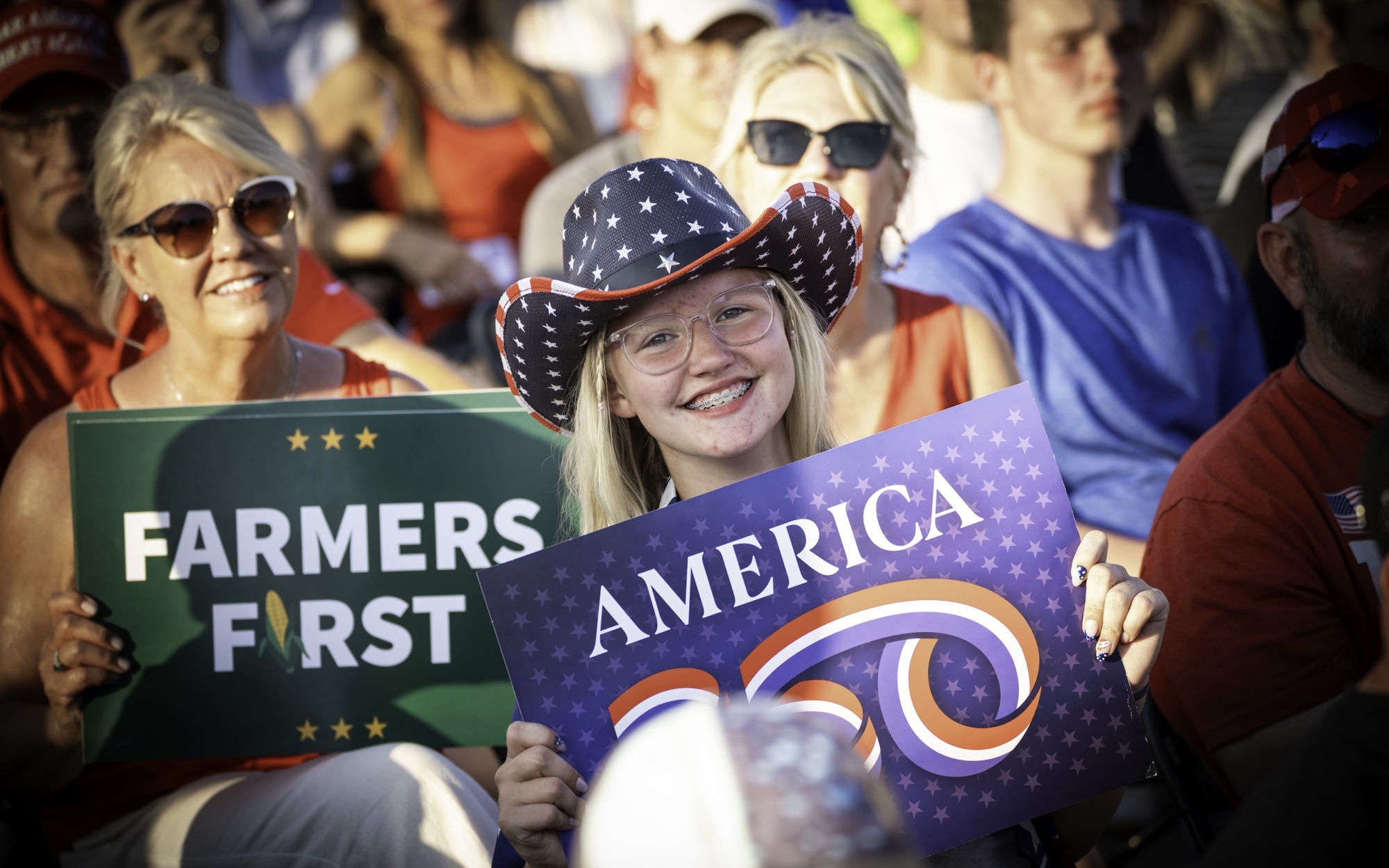 Smiling young girl with an America 250 sign at the America250 Iowa event on July 3 2025